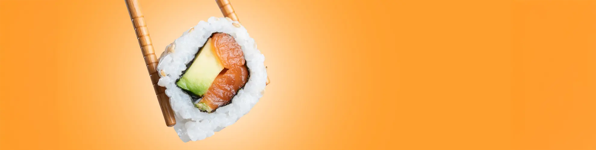 Salmon avocado sushi roll held by chopsticks